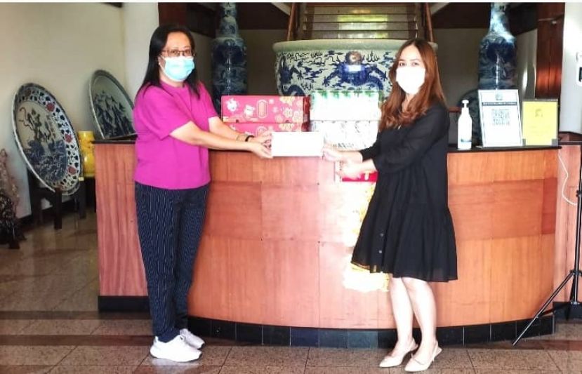 Trienekens（Sarawak）有限公司通讯组主任蔡依玲（右）移交礼品予国际时报，由采访主任林莉琳接收。