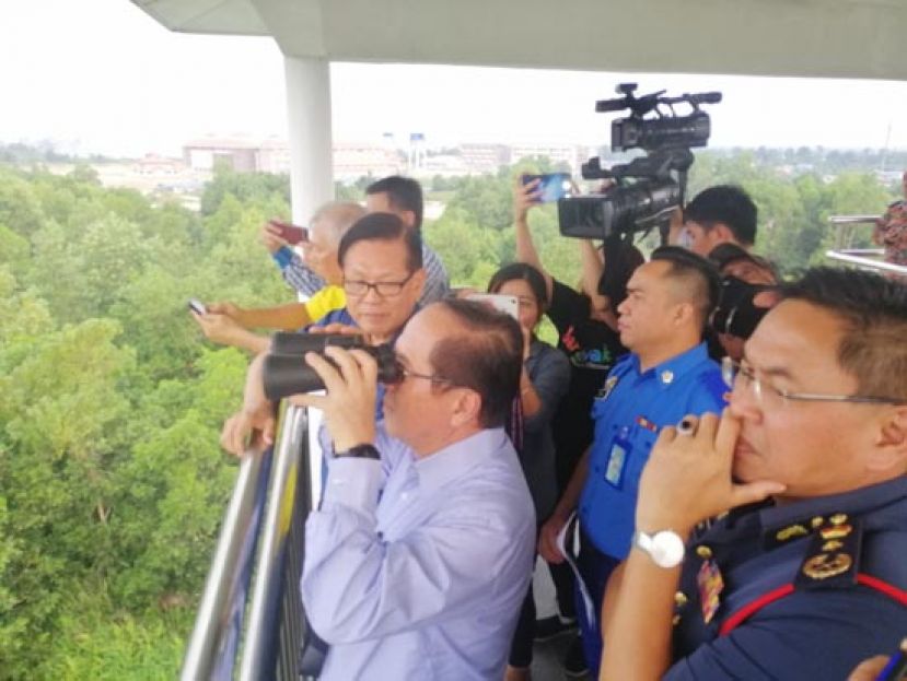 副首长道格拉斯在瞭望塔上，观察火点区的灾情。其右分别为陈超耀及李景胜，左为;砂消拯局局长凯鲁汀。