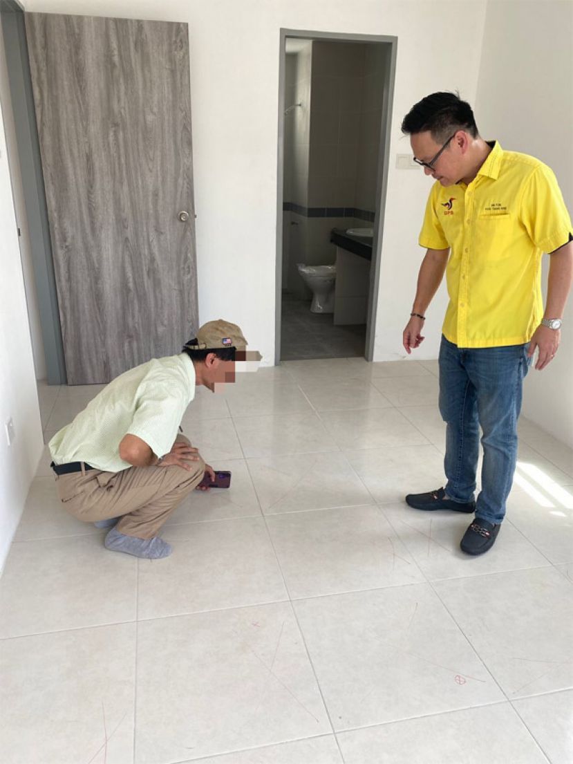 公寓单位事主向符祥威展示由地砖发出的空洞声音。