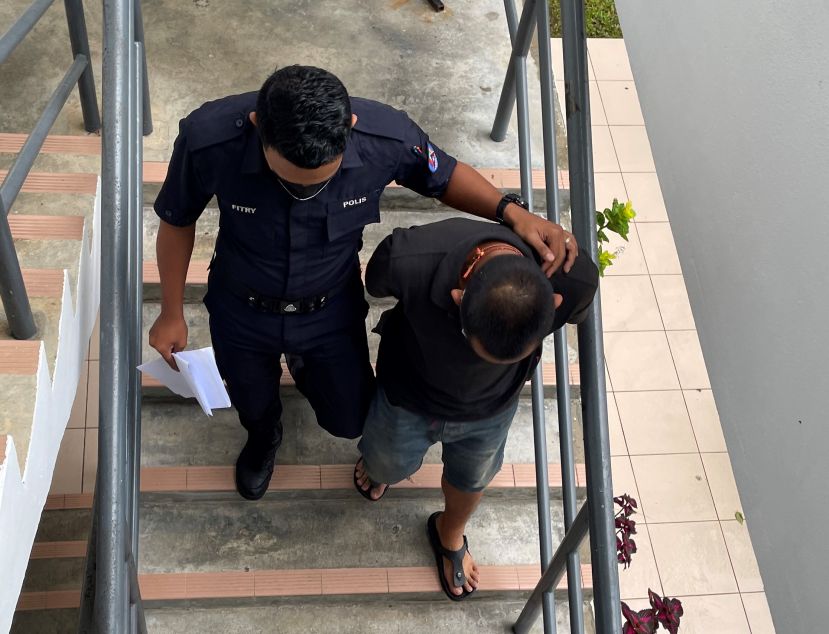 被告遭警员押离法庭时摄。