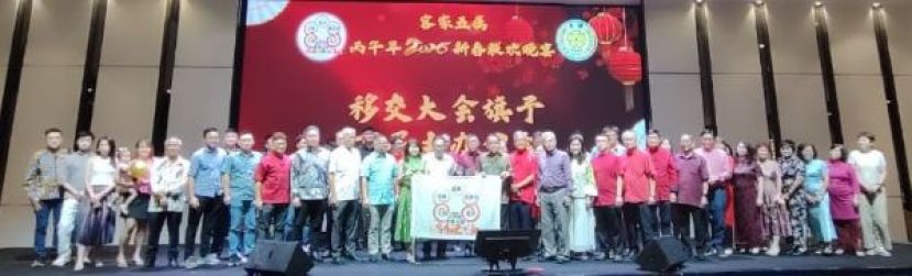 在众嘉宾以及客家五属主席及代表的见证下，晋汉连省大埔同乡会主席罗绍凤（左十二）移交大会旗予2027年的主办公会，即为砂拉越河婆同乡会，并由会长天猛公刘石星（由十五）接收时影。