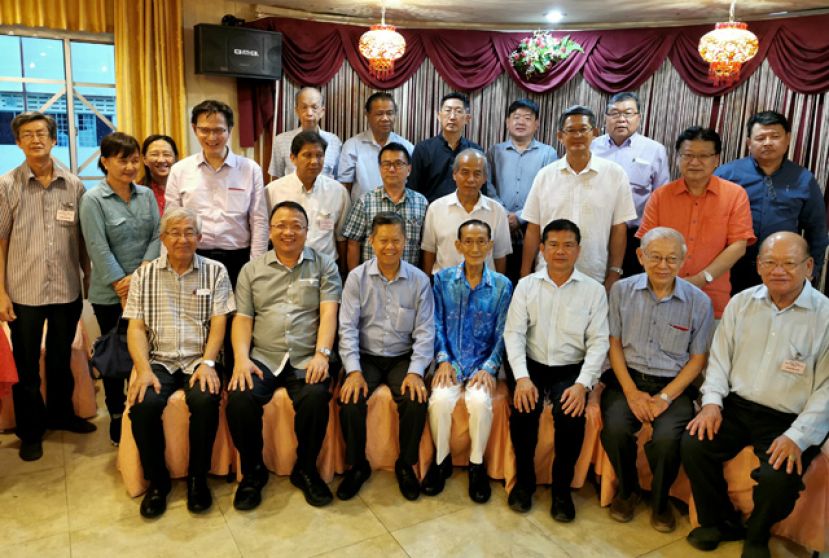 李开运(坐者右三)与林梦中华商会理事合摄于交流会上。