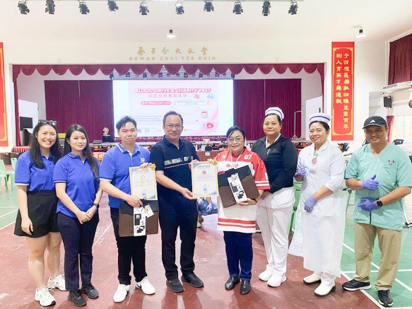 从左至右：林彩琴（数字营销员）、贝婉菁（业务发展执行员）、Tr赖政扬（Big Grain 活动负责人）、校长萧恭领先生、SGH 血库公共关系官,埃德娜 ，以及血库护士团队，一同接受感谢状与纪念品，以表彰他们在此次捐血及慈善活动中的付出与支持。