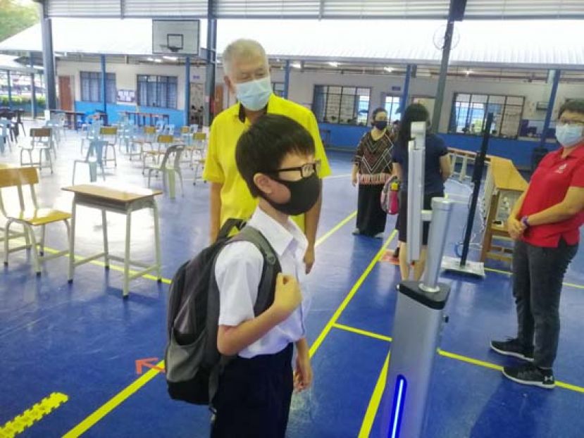 陈超耀在北校巡视，了解学生使用人脸识别终端仪测量体温。