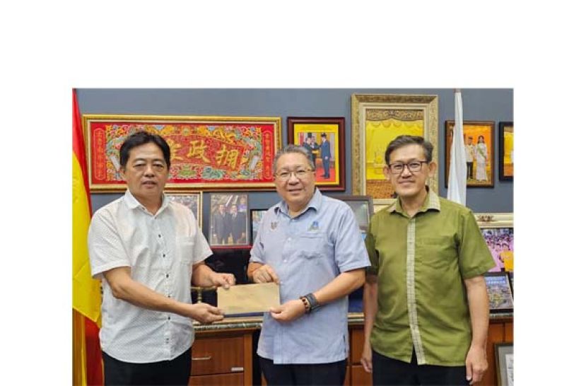 &ldquo;婆罗洲妈祖文化节&rdquo;庆典大会主席许义华（左）移交贵宾函予南市市长拿督黄鸿圣，右为庆典顾问薛华东。