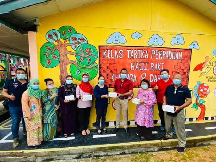 行动巴都吉当支部主席阿都阿兹（右四）把口罩移交予幼儿园负责人。