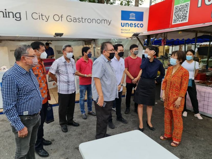 古晋中中校友会会长拿督黄国辉（中）与理事们莅临中国驻古晋总领馆的中华美食档，获中国驻古晋副总领事宋长虹（右一）与邵笑领事（右二）的热烈欢迎。