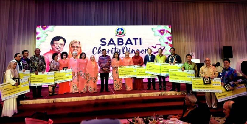 砂首长阿邦佐哈里与夫人拿汀巴丁宜拿督祖玛妮（中）与热心捐献善款的集团代表大合照。