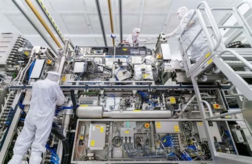 图为晶片制造设备业者艾司摩尔员工进行设备组装。