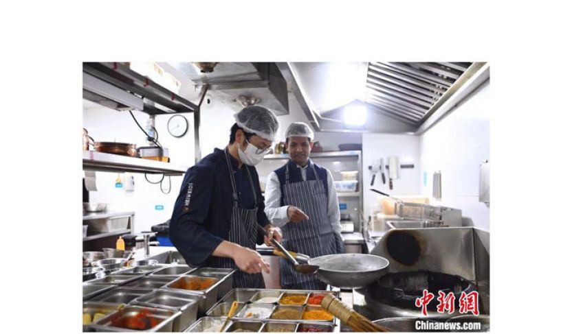 博文正在指导餐厅的厨师烹饪新菜。