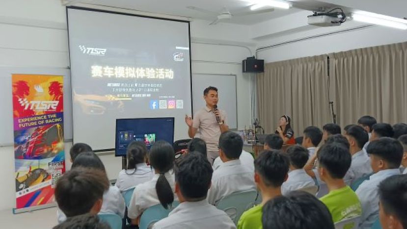 学生们专注聆听洪教练说明和分析模拟赛车这项电子竞技运动项目。
