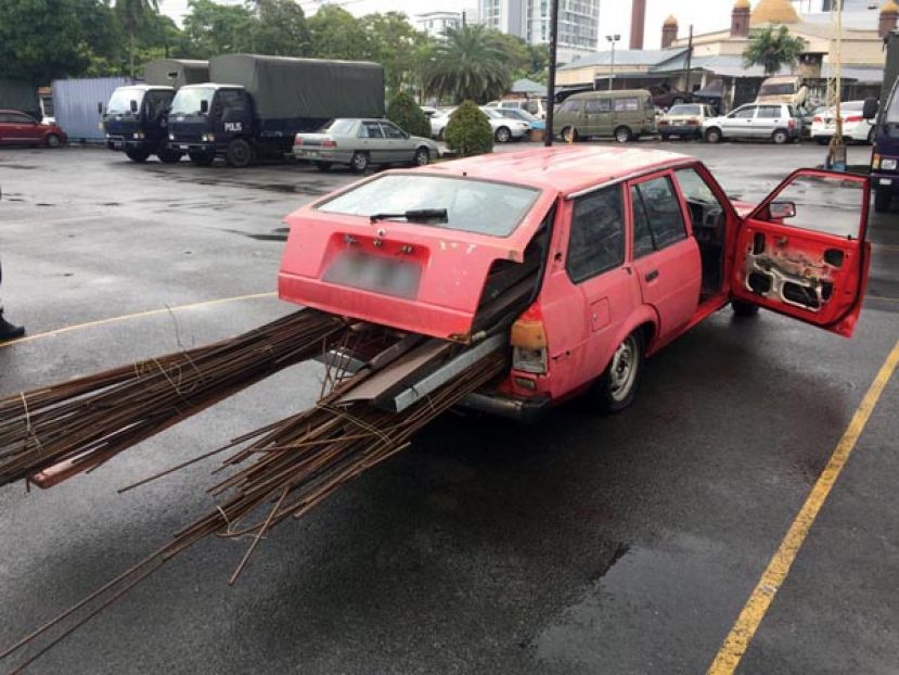 铁条搬上轿车，准备载走。