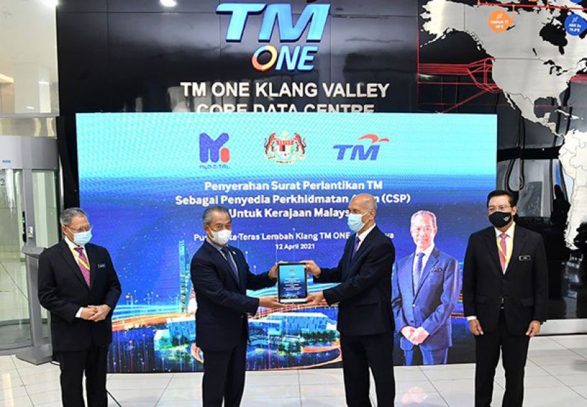 首相慕尤丁（左二）移交委任马电讯为政府云端服务供应商的委任信，予莫哈末巴克沙烈；左起为慕斯达法及莫哈末祖基。