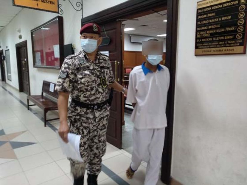 偷窃被揭发而亮刀威胁的被告被带离法庭。