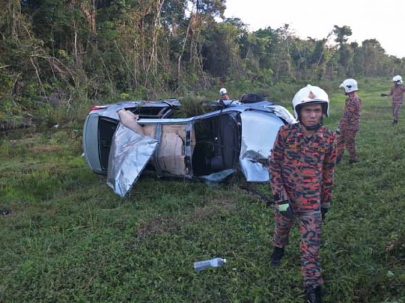 轿车拖上路边草地，损坏不堪。