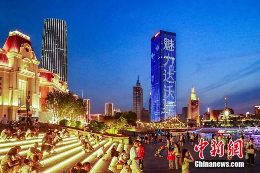 仲夏之夜，天津海河两畔多处楼宇滚动播放达沃斯宣传语。