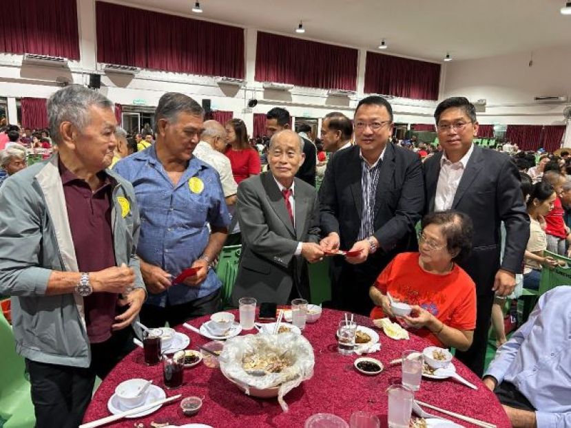 该会律顾问拿督蔡文铎(右二)在主席蔡岷谷(右一)陪同下，颁发敬老红包给该会执委蔡双利时摄。