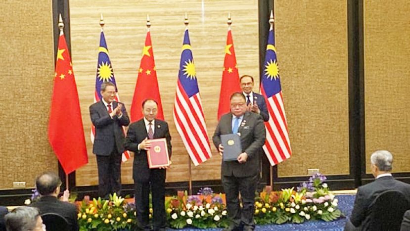 在首相拿督斯里安华（后右）及中国国务院总理李强（后左）见证下，中国驻马来西亚大使欧阳玉靖（左）与马来西亚旅游、艺术及文化部长拿督斯里张庆信（右）签署马中旅游合作谅解备忘录。
