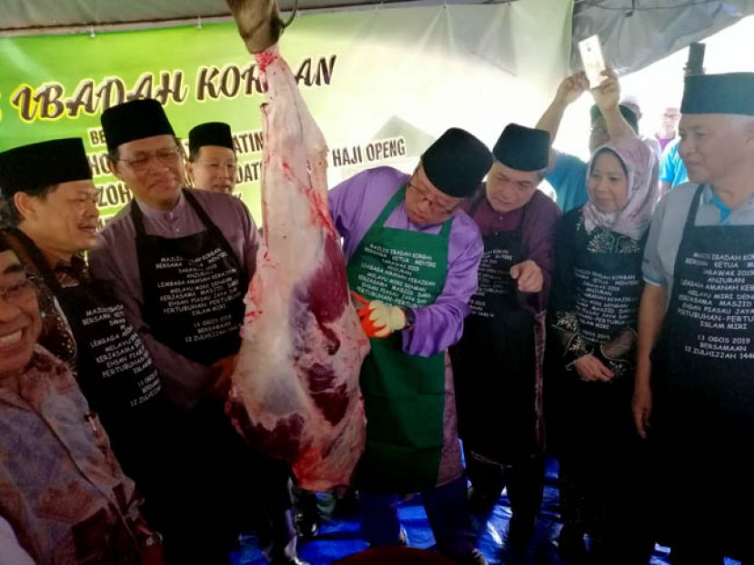 首长阿邦佐(右4)切割牛肉，以便派发给穆斯林信徒。右3；是美里马来福利信托局主席拿督哈志阿迪拉。