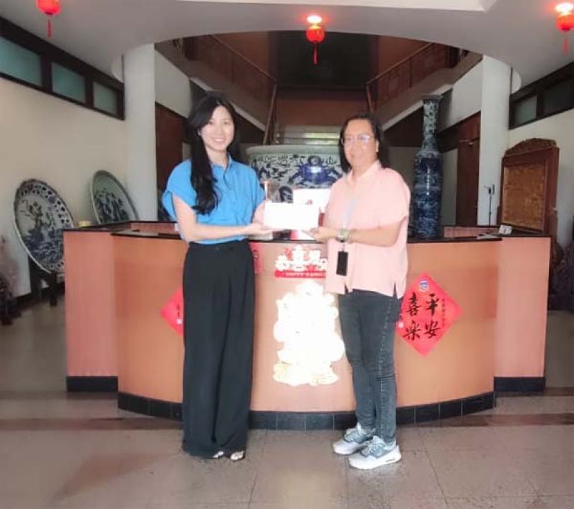 本报采访部主任林莉琳（右）从Trienekens (Sarawak) Sdn Bhd 高级企业传讯执行员苏沁凤手中接过礼品时影。