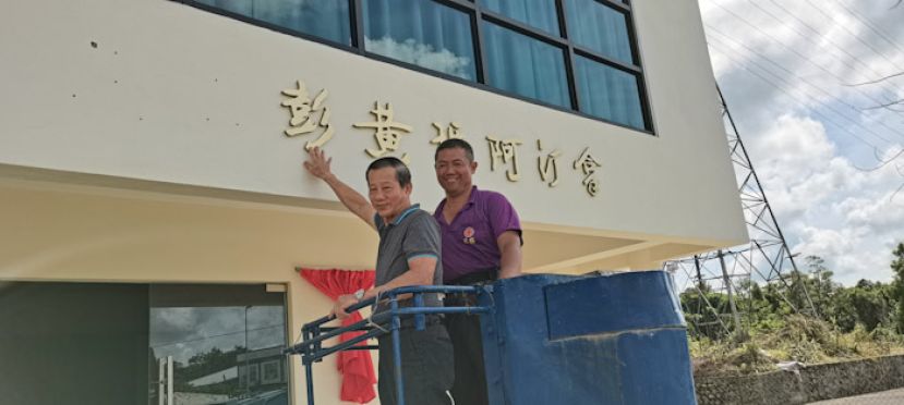 砂拉越彭氏公会会长彭德洲（左）昨日举行的简单上招牌仪式上，为《拿汀阿玛黄彭王莲会楼》招牌装上彭字时影。