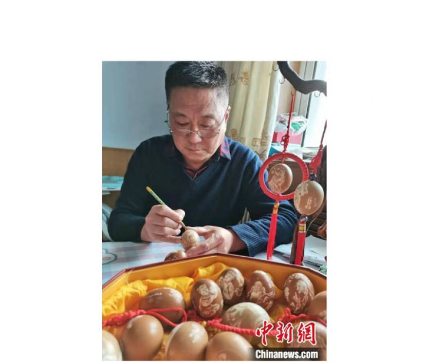 于迎年正在鸡蛋上进行雕刻。
