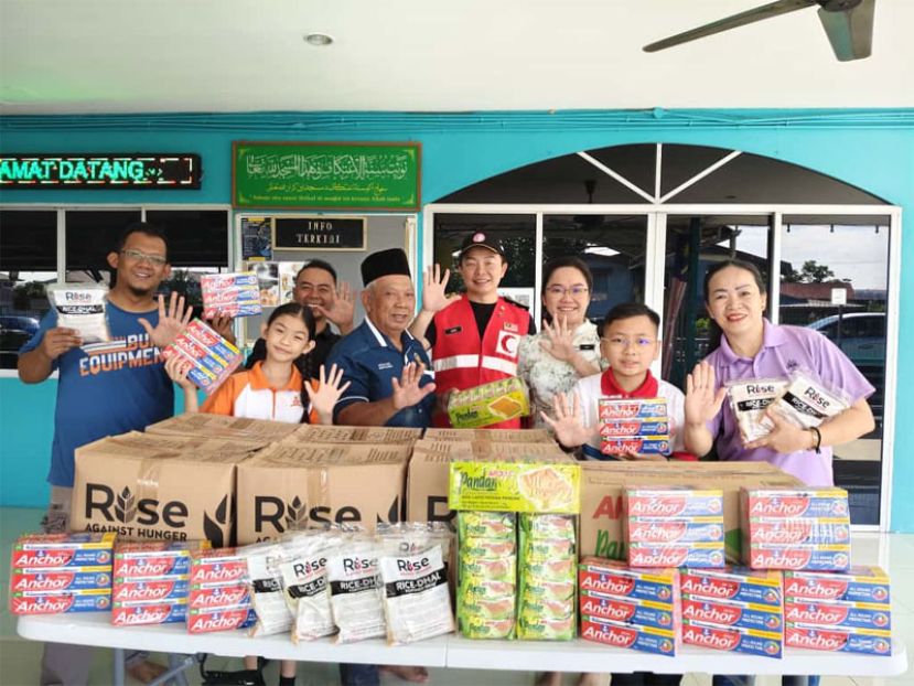 郑茗月校长与 周金顺一同将礼袋移交予 Ketua Kaum, Wain Sulaiman，以便转交予有需要的家庭成员。