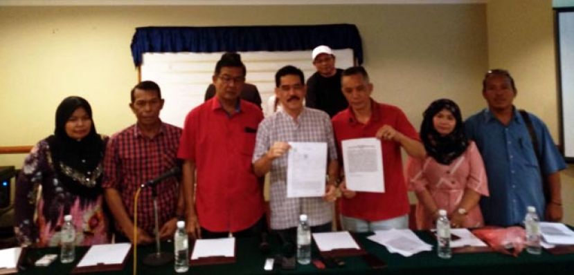 拿督斯里阿兹曼（中）在多名支持者陪同下展示报案书。 