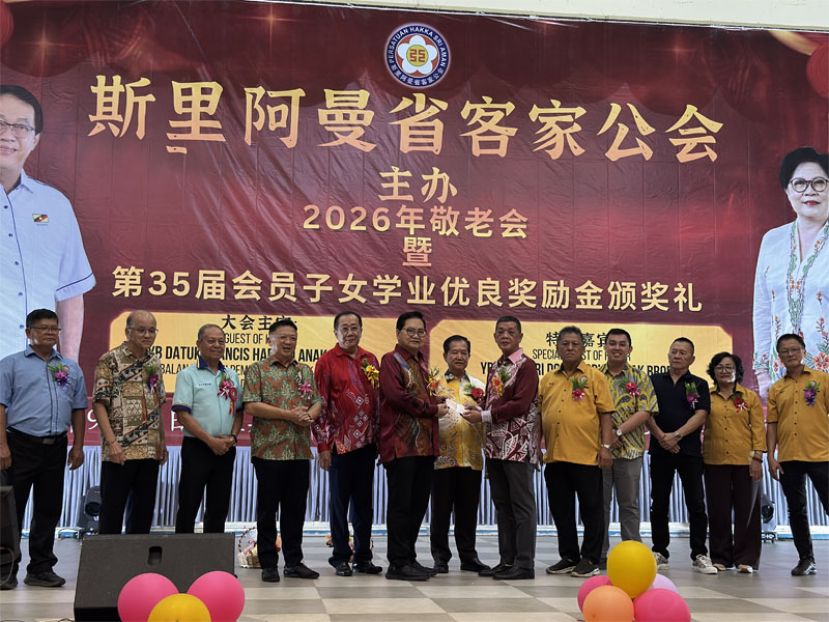 拿督吴标生（左六）在大家的见证下把支票移交给斯里阿曼省客家公会主席李志平（右六）。