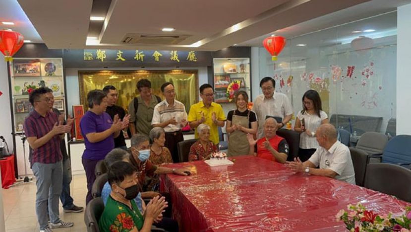 87岁寿星老人李亚华（坐），其右为38爱心慈善基金会代表兼古晉愛心書協會会长呂晗韻女士 站：左二副主席郭兴开右一理事郑文发.