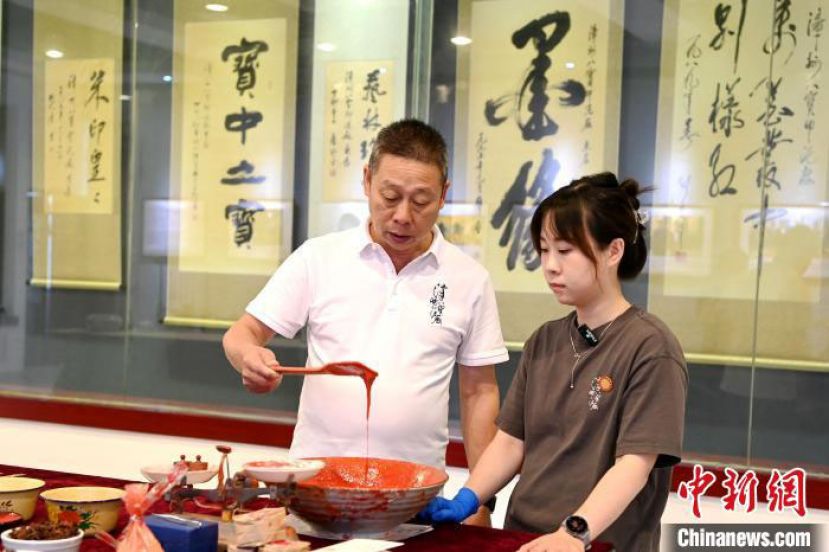 近日在漳州市八宝印泥厂研习大厅内，漳州市八宝印泥厂原厂长杨锡伟和他的女儿杨煜现场展示八宝印泥制作。
