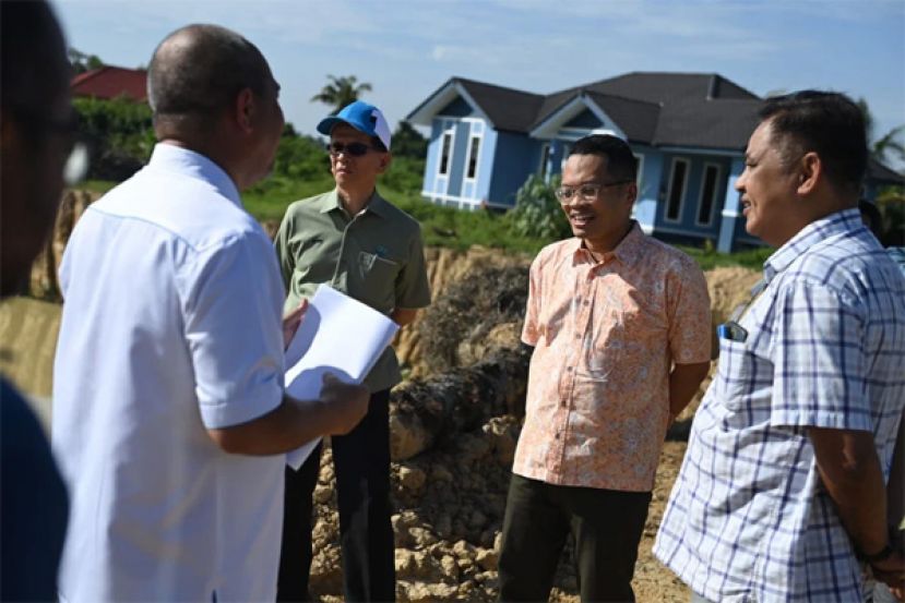 聂纳兹米（右二）巡视水利灌溉系统，并聆听官员汇报。