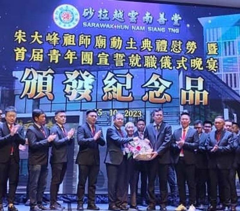 砂云南善堂主席郑文新（左五）移交纪念品予陈开（右三）时摄。