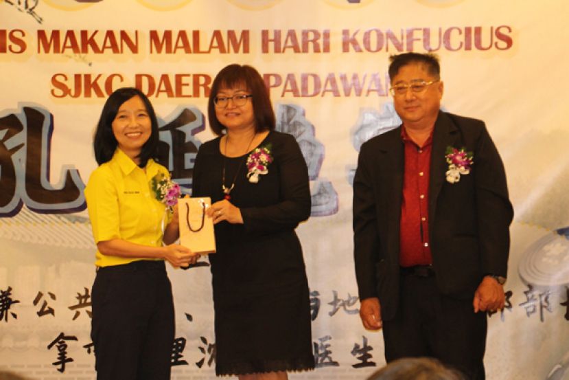 许德婉（左）颁发奖励给升任砂教育局助理局长的郑桂珠（中）；右为沈英明。