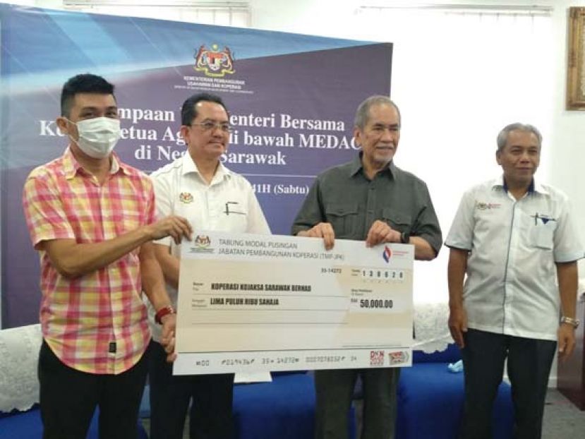 拿督斯里旺朱乃迪（右2）移交发展援助金予受惠者。