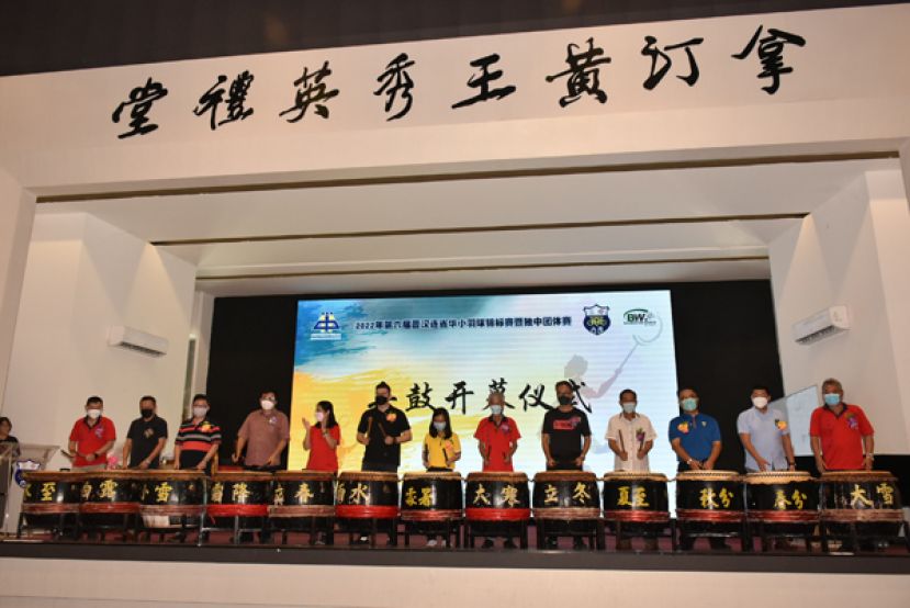 众嘉宾一起为2022年第六届晋汉连省华小羽球锦标赛暨独中团体赛主持击鼓开幕仪式，左起为三中校友会财政李闯何、赞助商陈龙云、Badminton World Sport有限公司东主蔡裕光、三中校友会永久名誉会长芦少奎、会长田玉燕、古晋区国会议员俞利文、古晋南市市议员许德婉、2022年第六届晋汉连省华小羽球锦标赛暨独中团体赛筹委会主席何爱民、三中校长李志鹏、赞助商林亚德、四中校长官晨阳、古晋中中校董会副主席沉楚鹏的代表沈茂前及三中校友会署理会长许孝智。