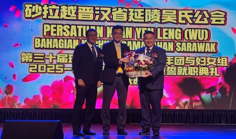 在砂晋汉省延陵吴氏公会会长拿督吴新贤的陪同下，该会三大机构宣誓就职典礼暨中秋节晚宴筹委会主席吴芝辉（右）赠送纪念品予主宾陈开时影。