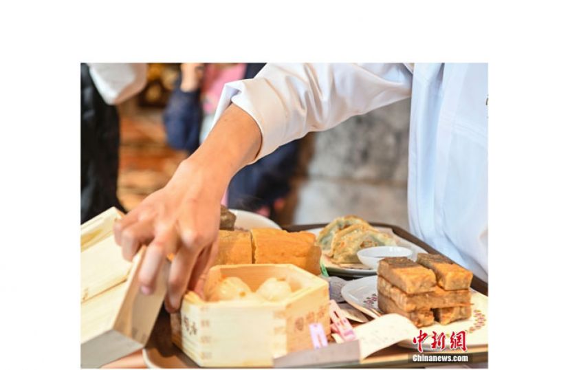 位于广东省广州市荔湾区第十甫路、有着141年历史的茶楼&ldquo;陶陶居&rdquo;总店，经过约两年半的修缮后重开迎客，一名服务员为顾客准备点心。