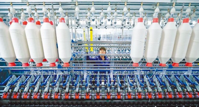 图为山东省青岛市一家工厂技术工人忙著组装生产线。