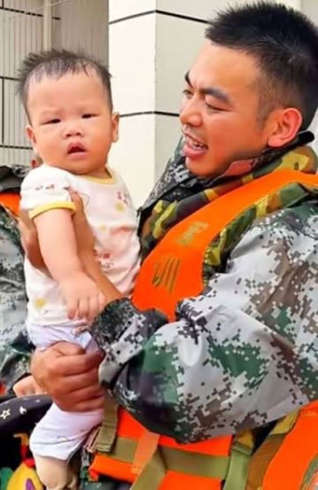 吴杰抱着从受灾区救出的婴儿。