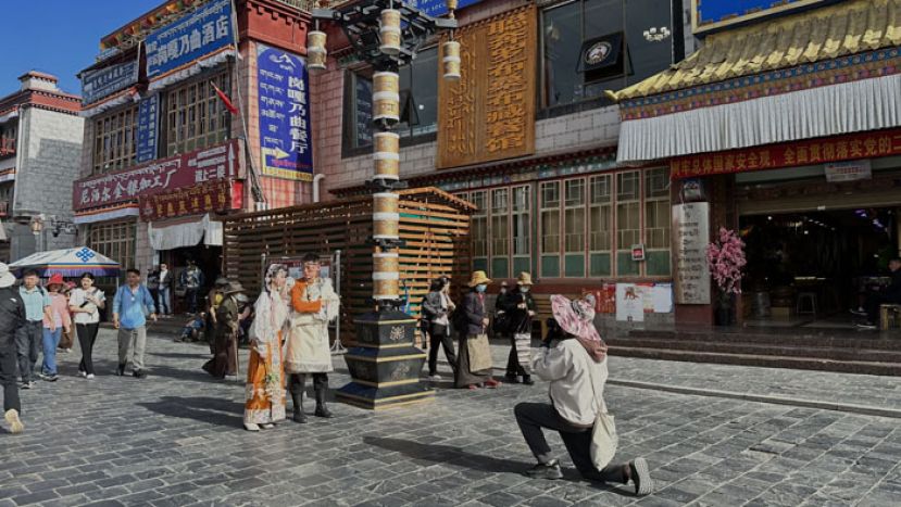 拉萨八廓街上，游客在拍摄藏服写真。