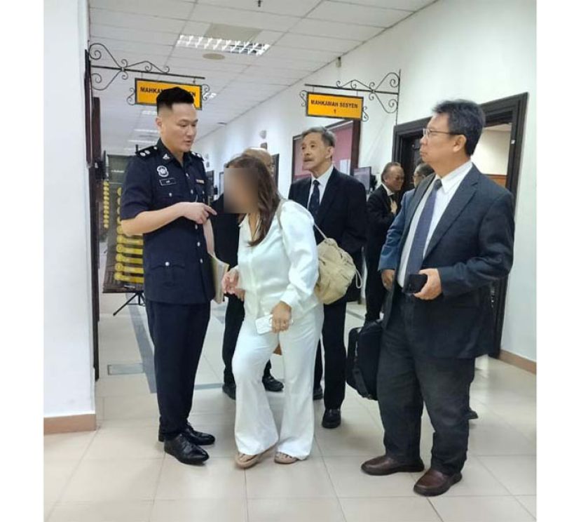 林进隆警长（左）和女被告交谈时影。右起为陈文达律师和林庆初律师。