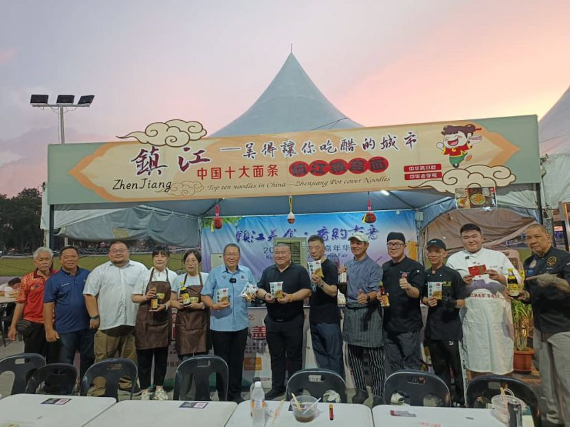 古晋南市市长拿督黄鸿圣昨晚与中国镇江餐饮服务行业协会常务副会长毕新军与古晋著名厨师介绍来自镇江的地道美食，包括锅盖面与驰名中外的镇江香醋。