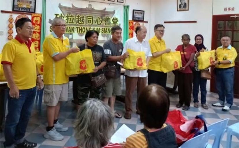 薛华东（右4起）、黄国远等人为砂同心善堂进行达雅节布施食品。左起为陈添发、李锦财；右是李汉标。