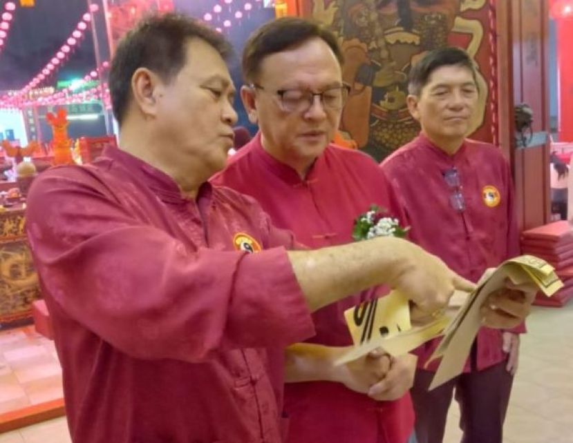 古晋东嶽观主席方文祥太平局绅（左）向拿督罗克强（中）介绍该观福品；右为方明生。