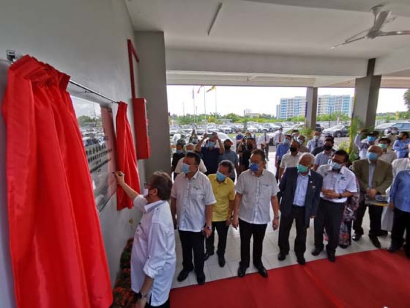 首长阿邦佐哈里在巴哥中华公学牌匾上签名时摄，其右为蔡文铎。