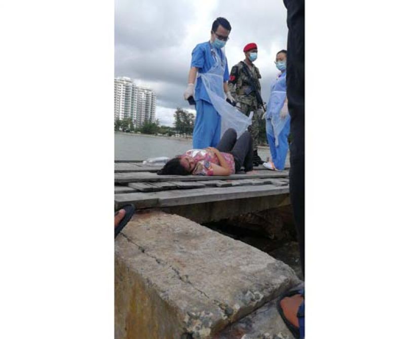 企图跳海自杀的女郎成功被拉上防浪堤。