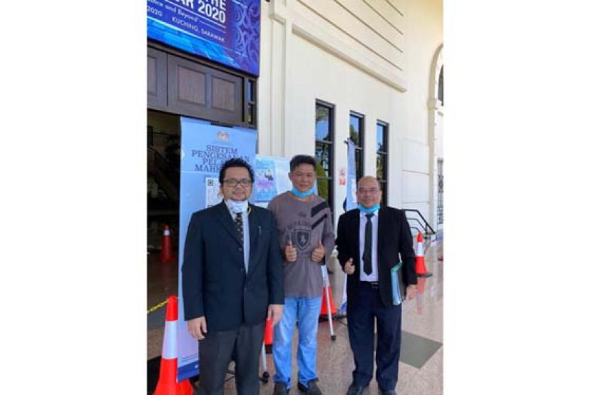 获得无罪释放的被告（中）和两名辩护律师影于法庭大厦外。