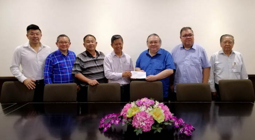 古晋中华中学校友会副会长拿督陈日枝（左四）移交邀请函予该会名誉会长拿督黄国忠（右三）时摄，左起为青年团团长陈玮政、校友会校友联系事务主任田荣喜、财政朱聪泽；右起为副会长翁岳春及会长暨活动筹委会主席拿督黄国辉。