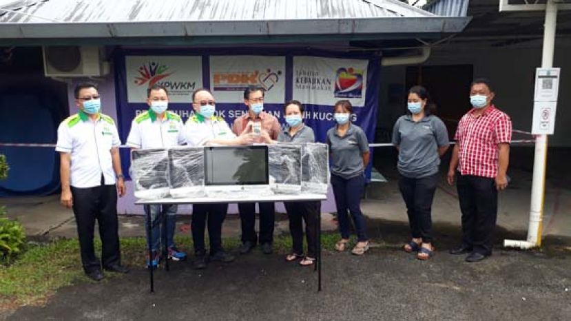 在砂人联党峇都林当支部主席兼古晋北市政行议员薛华东（左4）的见证下，刘思乐（左3）移交电脑予古晋爱心社区康复组织主管Wendy Mandau（右4）。左1与左2为马来西亚皇家爱心慈善协会砂区代表田志和、拿督谢在春。右1为陈德明。